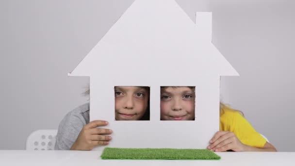 男孩和女孩正从纸板箱手工做的房子向外张望 慢动作 — 图库视频影像