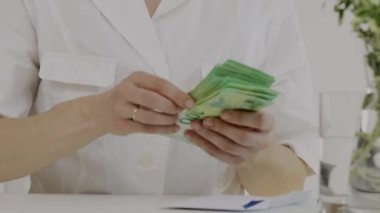 Medikal kız kardeşlerin giydiği beyaz kadın para sayıyor. - Yakın çekim. Yüksek kalite 4k görüntü