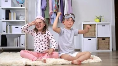 Pijama giymiş kız ve erkek kardeş birlikte eğleniyorlar. Ağır çekim. Yüksek kalite 4k görüntü