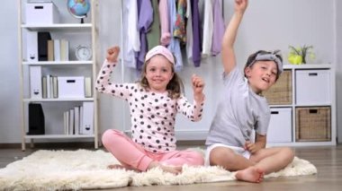 Pijama giymiş kız ve erkek kardeş birlikte eğleniyorlar. Ağır çekim. Yüksek kalite 4k görüntü