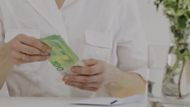 Medikal kız kardeşlerin giydiği beyaz kadın para sayıyor. - Yakın çekim. Yüksek kalite 4k görüntü