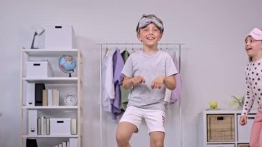 Pijama giymiş kız ve erkek kardeş birlikte dans ediyorlar. Ağır çekim. Yüksek kalite 4k görüntü
