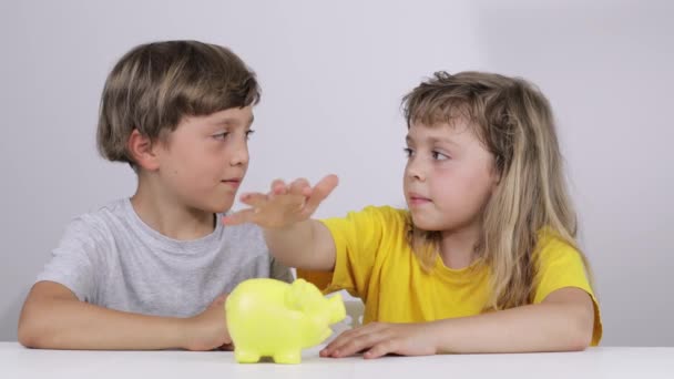 Brother Sister Putting Coins Piggy Bank Slow Motion — Stock Video