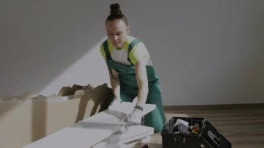 Young female is assembling a piece of furniture. High quality 4k footage