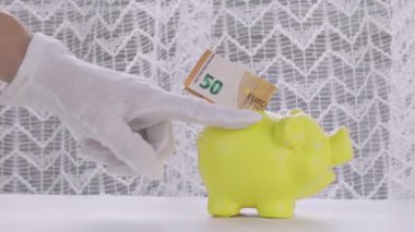 50 euro banknote in yellow piggy bank. Closeup. High quality 4k footage