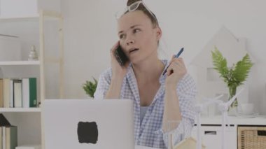 Female consultant is speaking on phone in front of pc
