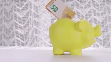 Human hand in white cotton glove takes 50 euro banknote from piggy bank. High quality 4k footage