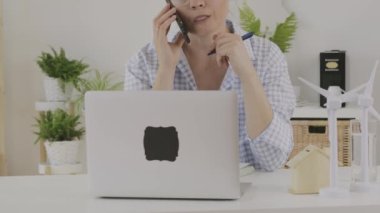 Female consultant is speaking on phone in front of pc