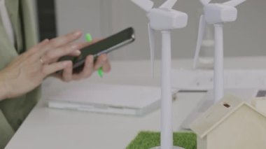 Model of wind turbines. Female with a smartphone out of focus. High quality 4k footage