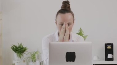 Young female between 30 and 40 yers old worried in the home office. 