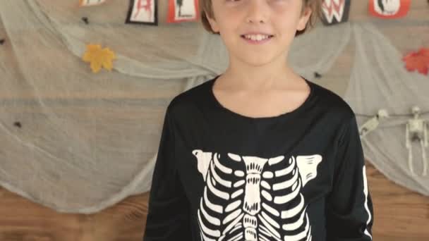 ハロウィーンの背景の前で冗談を作る8年の男の子 高品質4K映像 — ストック動画