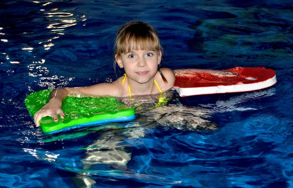 女孩在游泳池里游泳 — 图库照片