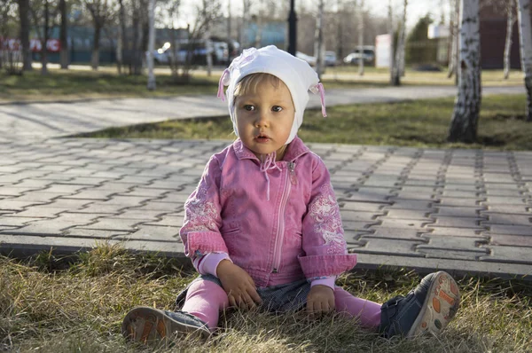 Toddler girl sitting on the ground — Stock Photo, Image