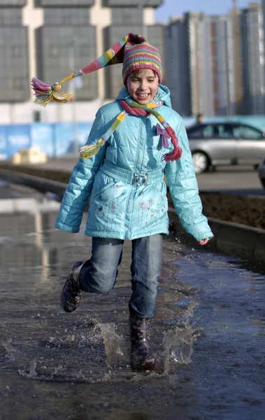 Mädchen springt in die Pfützen — Stockfoto