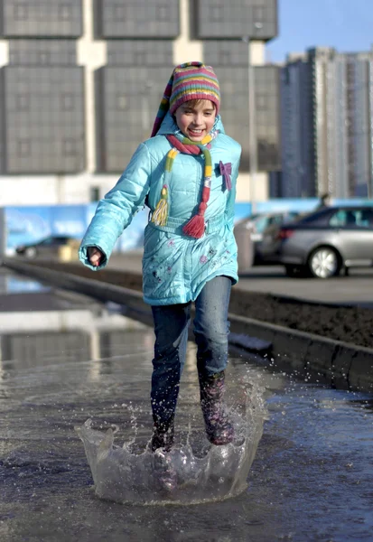 Mädchen springt in die Pfützen — Stockfoto