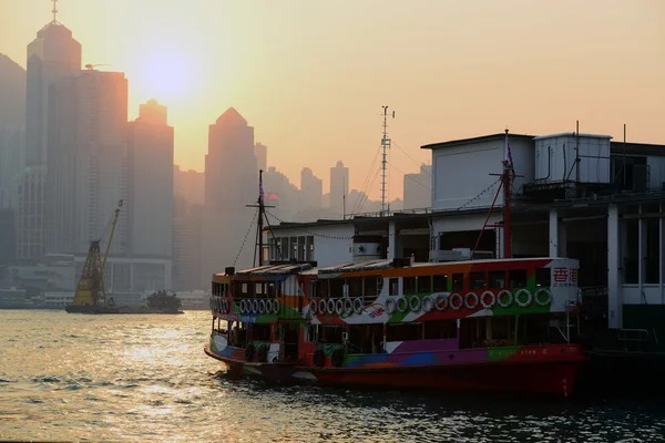 Traghetto e Hong Kong Victoria Harbour vista al tramonto — Foto Stock