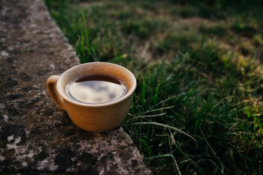 mug of coffee, tea on the background of home garden and sunset