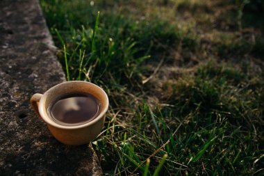 mug of coffee, tea on the background of home garden and sunset