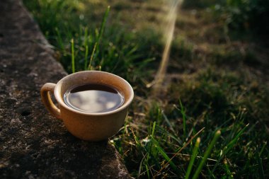 mug of coffee, tea on the background of home garden and sunset