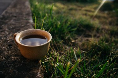 mug of coffee, tea on the background of home garden and sunset
