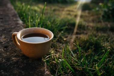 mug of coffee, tea on the background of home garden and sunset