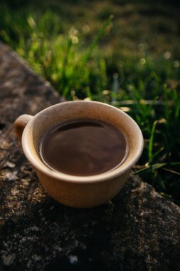 mug of coffee, tea on the background of home garden and sunset