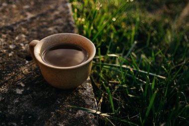 mug of coffee, tea on the background of home garden and sunset