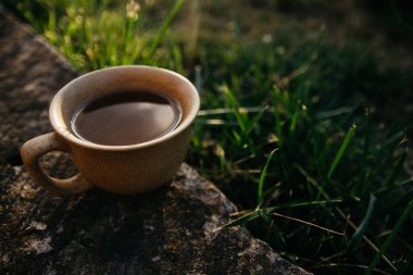 mug of coffee, tea on the background of home garden and sunset