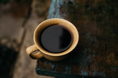 a cup of coffee stands on the table in gloomy and rainy weather.a cup of coffee in rainy weather