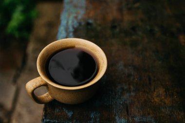 a cup of coffee stands on the table in gloomy and rainy weather.a cup of coffee in rainy weather