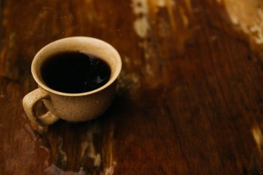 a cup of coffee stands on the table in gloomy and rainy weather.a cup of coffee in rainy weather