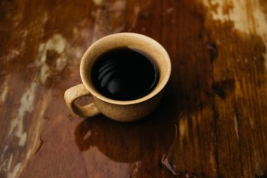 a cup of coffee stands on the table in gloomy and rainy weather.a cup of coffee in rainy weather