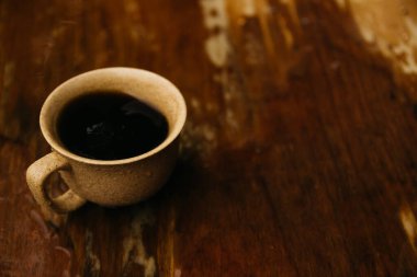 a cup of coffee stands on the table in gloomy and rainy weather.a cup of coffee in rainy weather