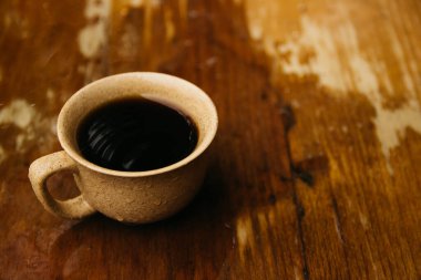 a cup of coffee stands on the table in gloomy and rainy weather.a cup of coffee in rainy weather