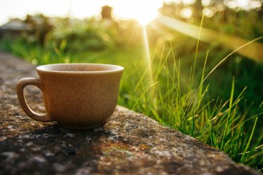 a cup of coffee on the background of the sunset.cup of coffee in the sunset