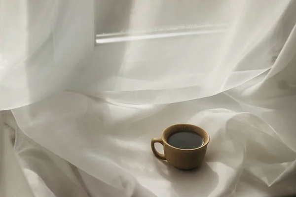 cup of coffee in the morning. espresso coffee. Coffee porridge on a white backgrounda cup of coffee on a white cloth. sun rays on a cup of coffee