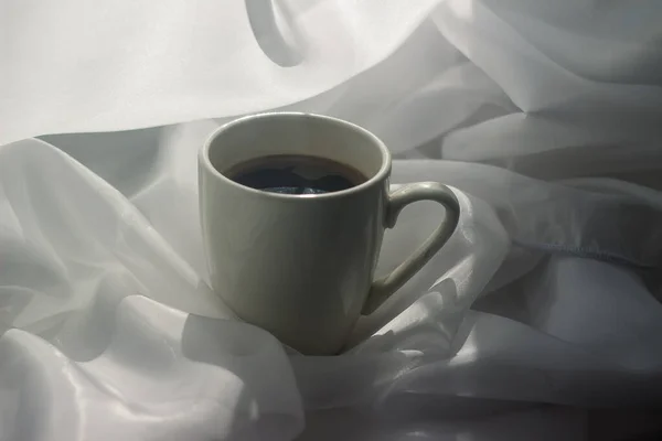 cup of coffee in the morning. espresso coffee. Coffee porridge on a white background a cup of coffee on a white cloth. sun rays on a cup of coffee