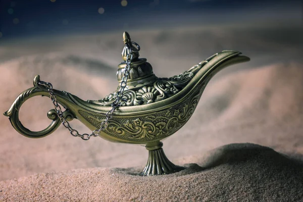 Magical Aladdin oil lamp in desert at night.