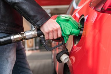 Adam kırmızı araçta yakıt istasyonu gaz pompalama.