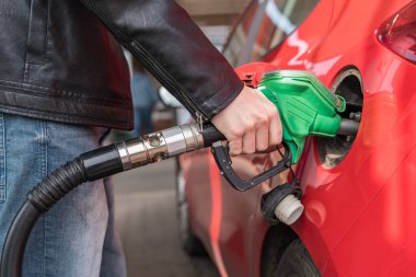 Adam kırmızı araçta yakıt istasyonu gaz pompalama.