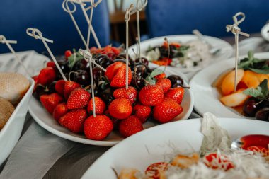 Sofrada bir tabakta sulu çilekler. Yakın plan.