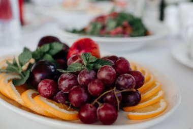 Sofrada bir tabakta sulu üzümler. Yakın plan.
