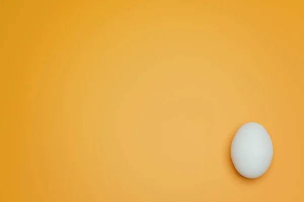Egy Fehér Tyúktojás Sárga Háttér Felülnézetben Kreatív Ételek Minimalista Háttere — Stock Fotó