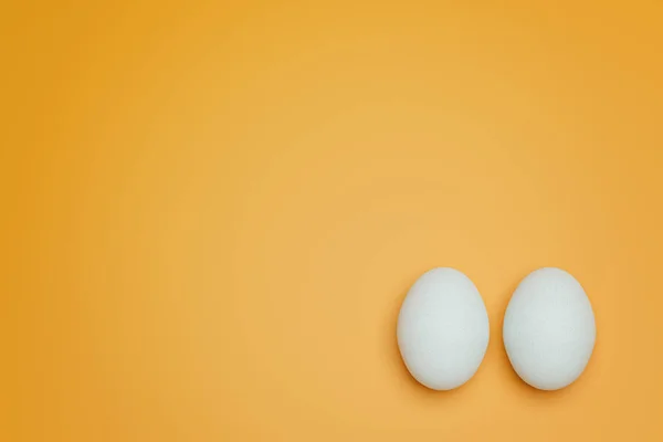 Két Fehér Csirke Tojás Sárga Háttér Felülnézetben Kreatív Ételek Minimalista — Stock Fotó