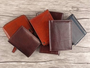 Açık ahşap arka planda yeni deri renkli cüzdanlar. Üst görünüm