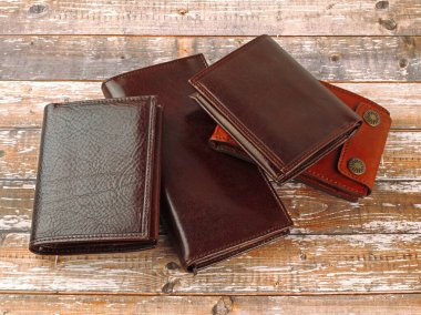 Açık ahşap arka planda yeni deri renkli cüzdanlar. Üst görünüm