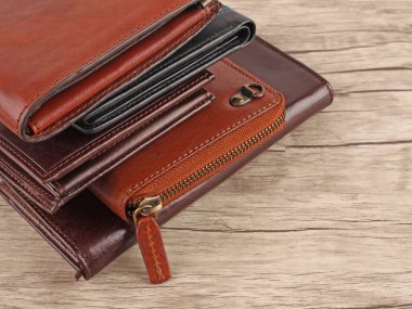 Açık ahşap arka planda çok renkli yeni deri cüzdanlar