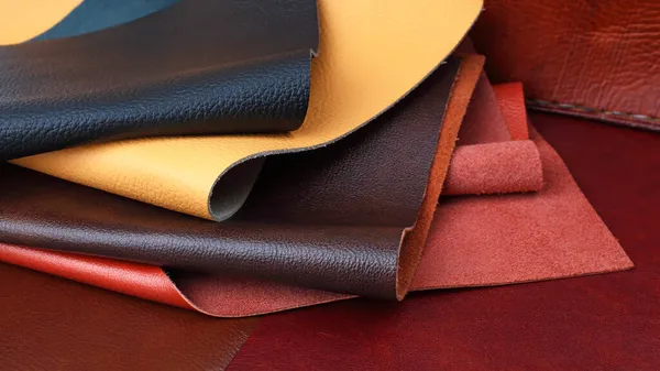 棕色皮革背景上不同颜色的天然皮革纹理样本 — 图库照片