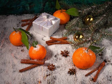 Mandalina, anason, tarçın, hediye kutusu, top ve köknar ağacının ağaç dalının Noel kompozisyonu ahşap karla kaplı yüzeyde
