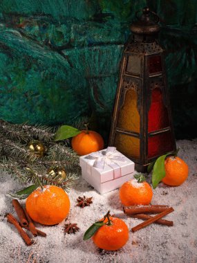Mandalina, anason, tarçın, hediye kutusu, toplar, köknar ağacı dalı ve kahverengi ahşap karla kaplı eski lambanın Noel kompozisyonu